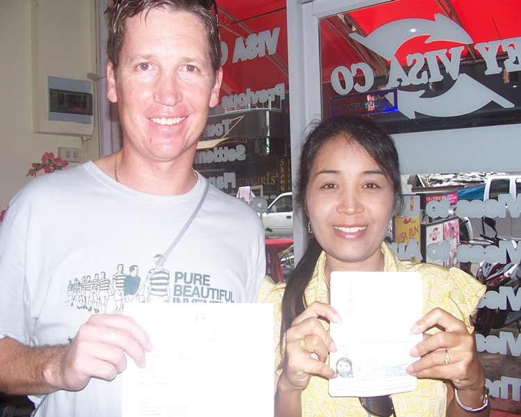 Happy clients Michael and Sompong smiling with their visa and paperwork