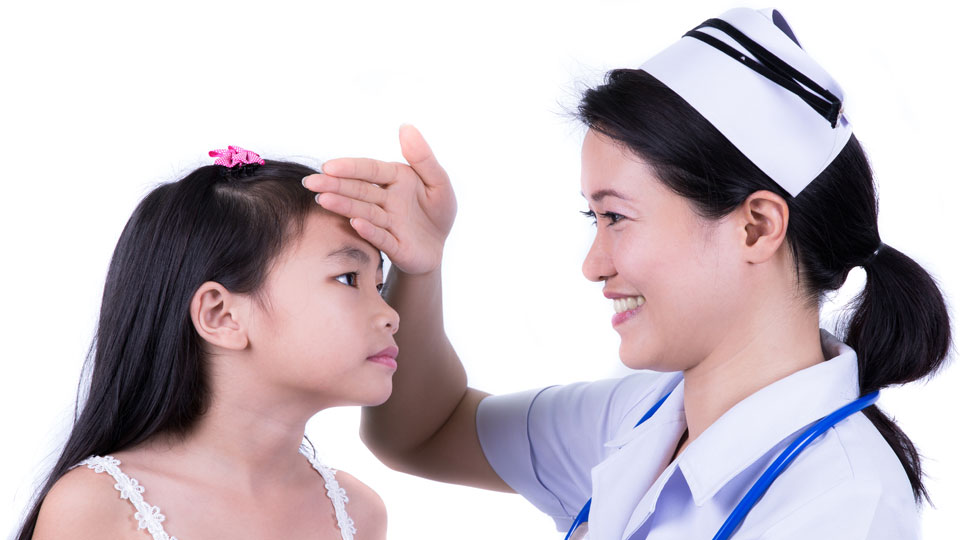 Nurse feeling a young girl's forehead to check her temperature