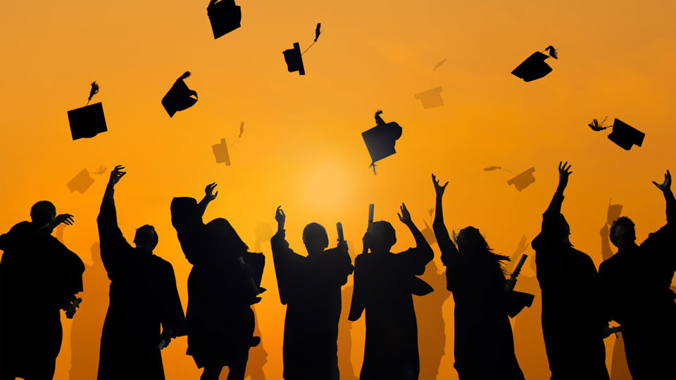 Silhouettes of Graduates Tossing Graduation Caps