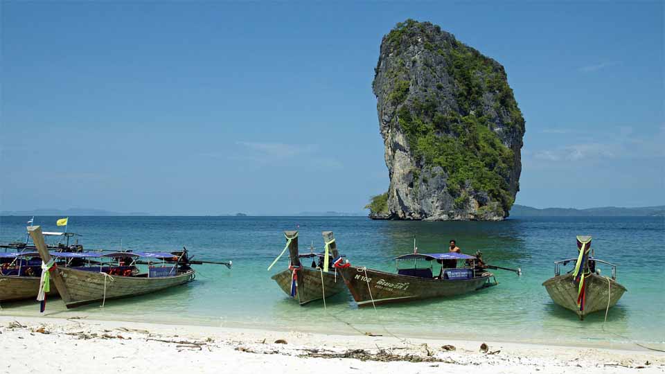 Old fashioned boats anchored to an island beach