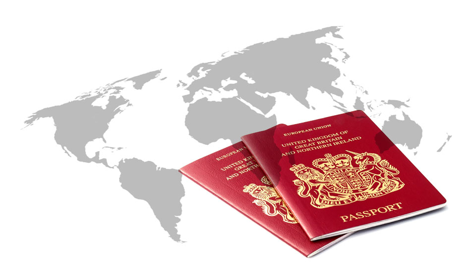 two UK passports over a map of the world