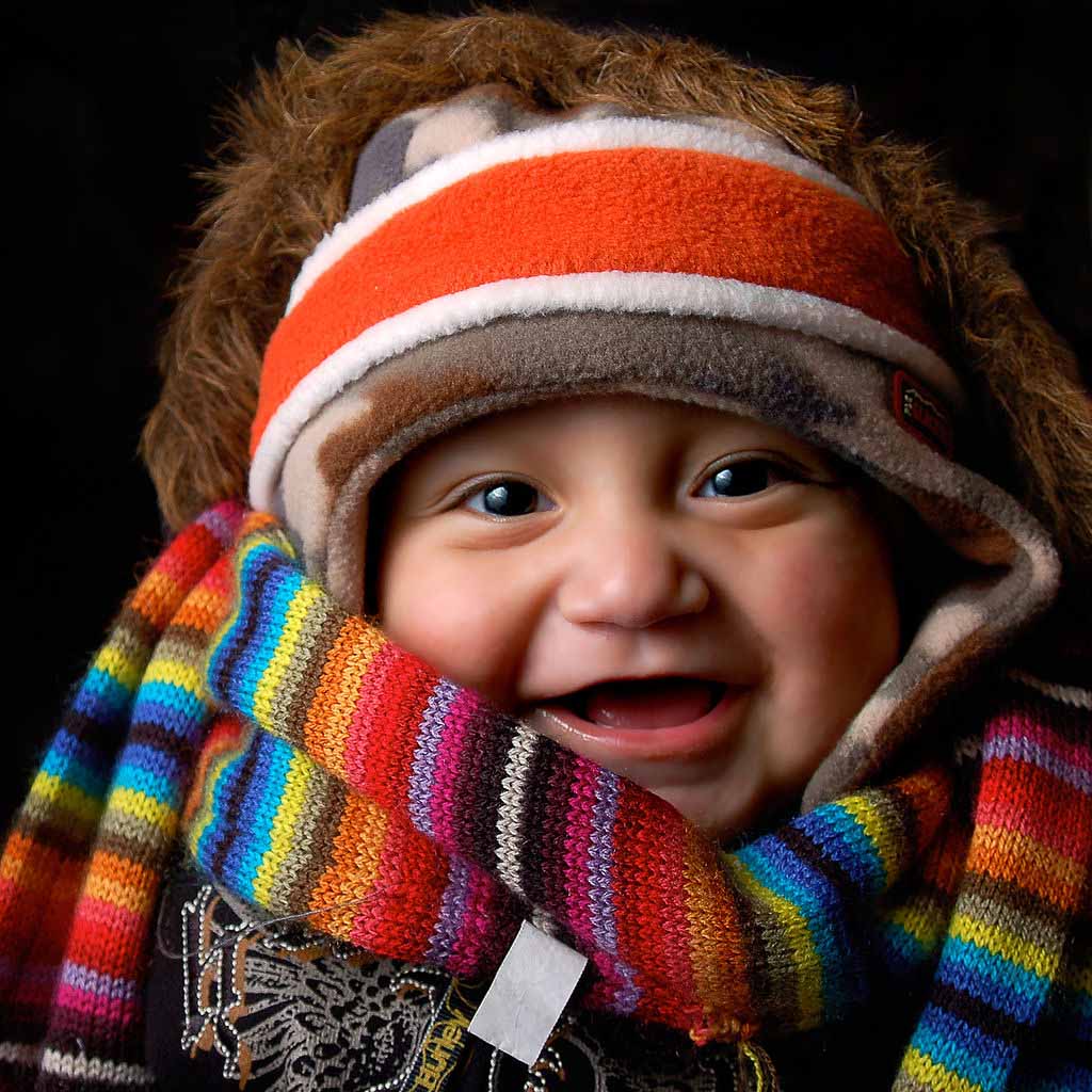 Happy baby in a very colorful scarf
