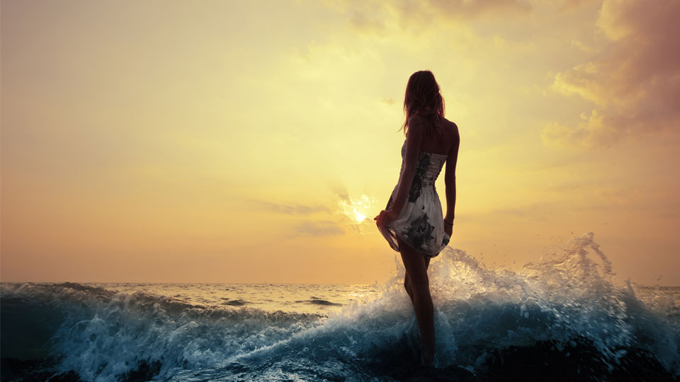 A pretty woman in a short dress in the surf