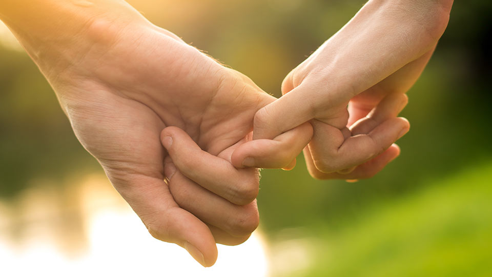 A couple holding pinkies